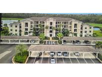 Beautiful condo exterior with covered parking, lush landscaping, and a view of the surrounding community at 17520 Gawthrop Dr # 106, Lakewood Ranch, FL 34211