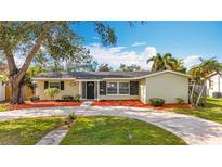 Charming one-story home featuring a well-maintained front yard with mature trees and a circular driveway at 3124 61St N Ln, St Petersburg, FL 33710