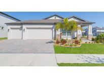 Charming single-story home featuring a three-car garage, well-manicured lawn, and inviting curb appeal at 33277 Rosewood Bark Way, Wesley Chapel, FL 33545