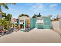 Charming, blue single-story home with a white porch and inviting yellow front door at 4570 67Th N St, St Petersburg, FL 33709