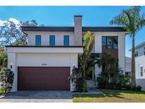 Contemporary two-story home featuring modern architecture, well-kept lawn, and a stylish brown garage door at 4604 W Lowell Ave, Tampa, FL 33629