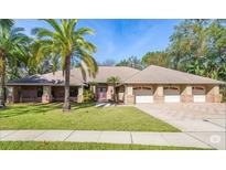Beautiful single-story home featuring a three-car garage, mature landscaping, and a well-maintained lawn at 70 Deerpath Dr, Oldsmar, FL 34677
