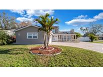 Charming single-Gathering home with manicured lawn, decorative palm trees, and brick-paved driveway at 15701 Springmoss Ln, Tampa, FL 33624