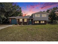 Charming two-story home features a brick facade and a lush green lawn at 407 Cranberry Ln, Brandon, FL 33510