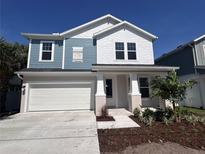 Charming two-story home with a two-car garage, lovely landscaping and a blue accent at 509 N Bradford Ave, Tampa, FL 33609