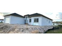 New construction home shows a modern exterior with a separate garage and landscaping to be completed at 13224 Foresman Blvd, Port Charlotte, FL 33981