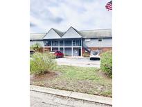 Two-story condo with a blue exterior, brick accents, stairs leading to the second floor and an American flag waving in the wind at 200 Country Club Dr # 407, Largo, FL 33771