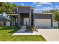 Contemporary two-story home with a gray exterior, a rooftop deck, and an attached one car garage at 4406 W Euclid Ave, Tampa, FL 33629
