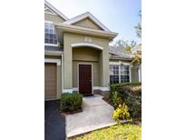 Charming townhome entrance features a well-maintained landscape and welcoming front door with clean sidewalk at 3673 Kings Rd # 102, Palm Harbor, FL 34685