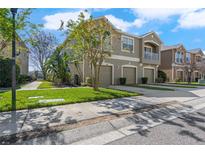 Charming three-car garage townhome with a manicured lawn and private second story balcony at 8835 Moonlit Meadows Loop, Riverview, FL 33578