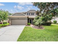 Charming two-story home with a well-manicured lawn, mature trees and two car garage at 19308 Sunset Bay Dr, Land O Lakes, FL 34638