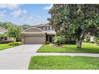 Charming two-story home features a well-manicured lawn, mature trees and an attached two-car garage at 19308 Sunset Bay Dr, Land O Lakes, FL 34638