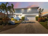 Charming two-story home with landscaped yard, two-car garage, and balcony at 727 Key Royale Dr, Holmes Beach, FL 34217