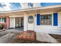 Charming home featuring a quaint front door with bright blue shutters and a decorative tiled entryway at 10022 Lily N St # N, Pinellas Park, FL 33782