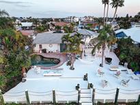 A stunning waterfront property with a beautiful pool, spacious deck, and lush tropical landscaping perfect for outdoor living at 6446 Lake Sunrise Dr, Apollo Beach, FL 33572