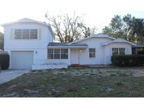 Traditional, white, single-Gathering home featuring an attached garage and small front yard at 8706 N 34Th St, Tampa, FL 33604