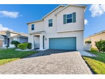 Beautiful two-story home featuring a blue garage door, well-maintained landscaping, and a paved driveway at 11827 Cara Field Ave, Riverview, FL 33579