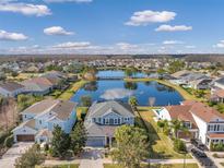 Beautiful aerial view of neighborhood homes surrounding a lake with a walking bridge on a sunny day at 2575 Claymore St, Odessa, FL 33556