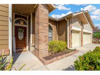 Inviting front entrance featuring a solid wood door, sidelight, and brick accents at 11209 Bloomington Dr, Tampa, FL 33635