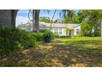 Charming single-story home with a lush front yard and mature trees providing ample shade at 1372 Palmetto St, Clearwater, FL 33755
