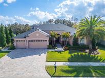 Charming single-story home featuring a three-car garage, lush landscaping, and a well-manicured lawn at 2903 Marble Crest Dr, Land O Lakes, FL 34638
