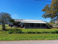 Charming single-story home with a metal roof, fenced yard, and mature trees at 1115 27Th Se St, Ruskin, FL 33570