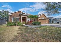 Charming single Gathering home featuring a stone facade, three car garage, and beautiful landscaping at 11713 Summer Springs Dr, Riverview, FL 33579