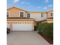 Two-story townhouse featuring a spacious two-car garage, well-maintained landscaping, and a welcoming green front door at 6980 Ulmerton Rd # 8C, Largo, FL 33771