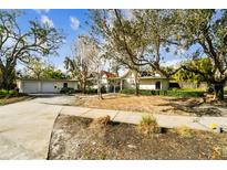 Charming single-story home with beautiful mature trees and a spacious front yard with ample parking space at 4811 Paradise S Way, St Petersburg, FL 33705