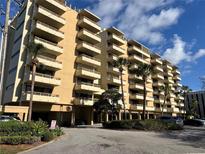 Low angle shows the exterior of the condo building with palm trees and parking at 5701 Mariner St # 606, Tampa, FL 33609