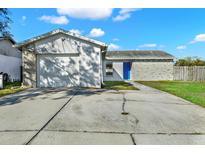 Charming single-story home featuring a large driveway and an attached garage at 912 Lochmont Dr, Brandon, FL 33511