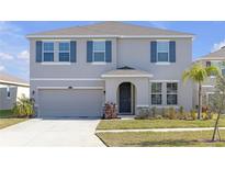 Charming two-story home with blue shutters, a well-maintained lawn, and an attached two-car garage at 10944 Delta Huff Ct, San Antonio, FL 33576