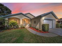Charming single-Gathering home featuring a manicured lawn and a welcoming front porch at 11427 Turtle Dove Pl, New Port Richey, FL 34654