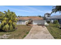 Charming single-story home featuring an attached two-car garage and a well-maintained front yard at 13614 Evelane Dr, Hudson, FL 34667