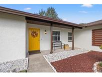 Inviting front porch with yellow door and decorative wreath at 5834 71St N St, St Petersburg, FL 33709