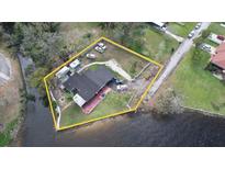 An aerial view of waterfront property with a home, mature trees and driveway parking for multiple vehicles at 2102 W Ivy St, Tampa, FL 33607