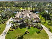 Stunning two-story home with a manicured lawn, circle driveway, and lush landscaping at 4110 Highland Park Cir, Lutz, FL 33558