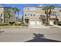 A tan townhouse with a two-car garage and palm trees in the front yard at 2967 Bayshore Pointe Dr, Tampa, FL 33611