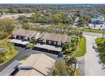 Aerial view of condo building with mature landscaping and covered parking at 4008 Passport Ln # 104, New Port Richey, FL 34653