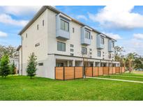 Modern townhome exterior featuring a manicured lawn and wood privacy fences at 532 W Plaza Pl # 2, Tampa, FL 33602