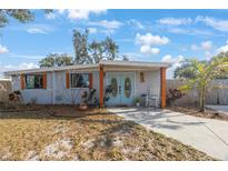 Charming home exterior featuring blue double doors, freshly painted stucco and a well-manicured front yard at 9169 Robin Rd, Seminole, FL 33777