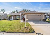 Charming single-story home showcasing a well-manicured lawn and a two-car garage at 11018 Courtland St, Trinity, FL 34655