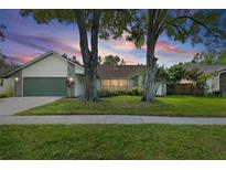 Charming single-story home with mature trees, lush lawn, and a two-car garage at 1740 Shady Leaf Dr, Valrico, FL 33596