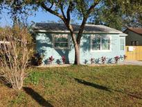 Charming, light blue single-story home with tidy landscaping, lush lawn, and mature tree at 2432 Auburn S St, St Petersburg, FL 33712