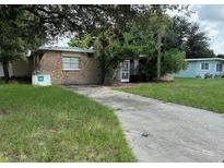 Cozy stone home featuring a charming front yard and concrete driveway at 5507 Forest Hills Dr, Holiday, FL 34690