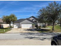 Charming single-story home with a three-car garage, lush landscaping, and a well-maintained lawn at 6601 Thackston Dr, Riverview, FL 33578