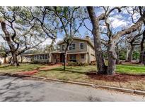 Charming home exterior with mature trees, a brick walkway, and colorful landscaping at 2901 Pelham Rd, St Petersburg, FL 33710