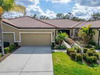 Charming single-story home featuring a tile roof, a two-car garage, and well-manicured landscaping at 438 Seneca Falls Dr, Apollo Beach, FL 33572
