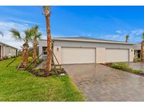 New construction home showcasing a two-car garage and well-maintained landscaping with stone accents at 6212 Timberdale Ave, Wesley Chapel, FL 33545