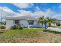 Charming single-story home with neat front lawn, accent palm tree, and a lovely blue sky at 702 W Brockton Pl # 2, Sun City Center, FL 33573